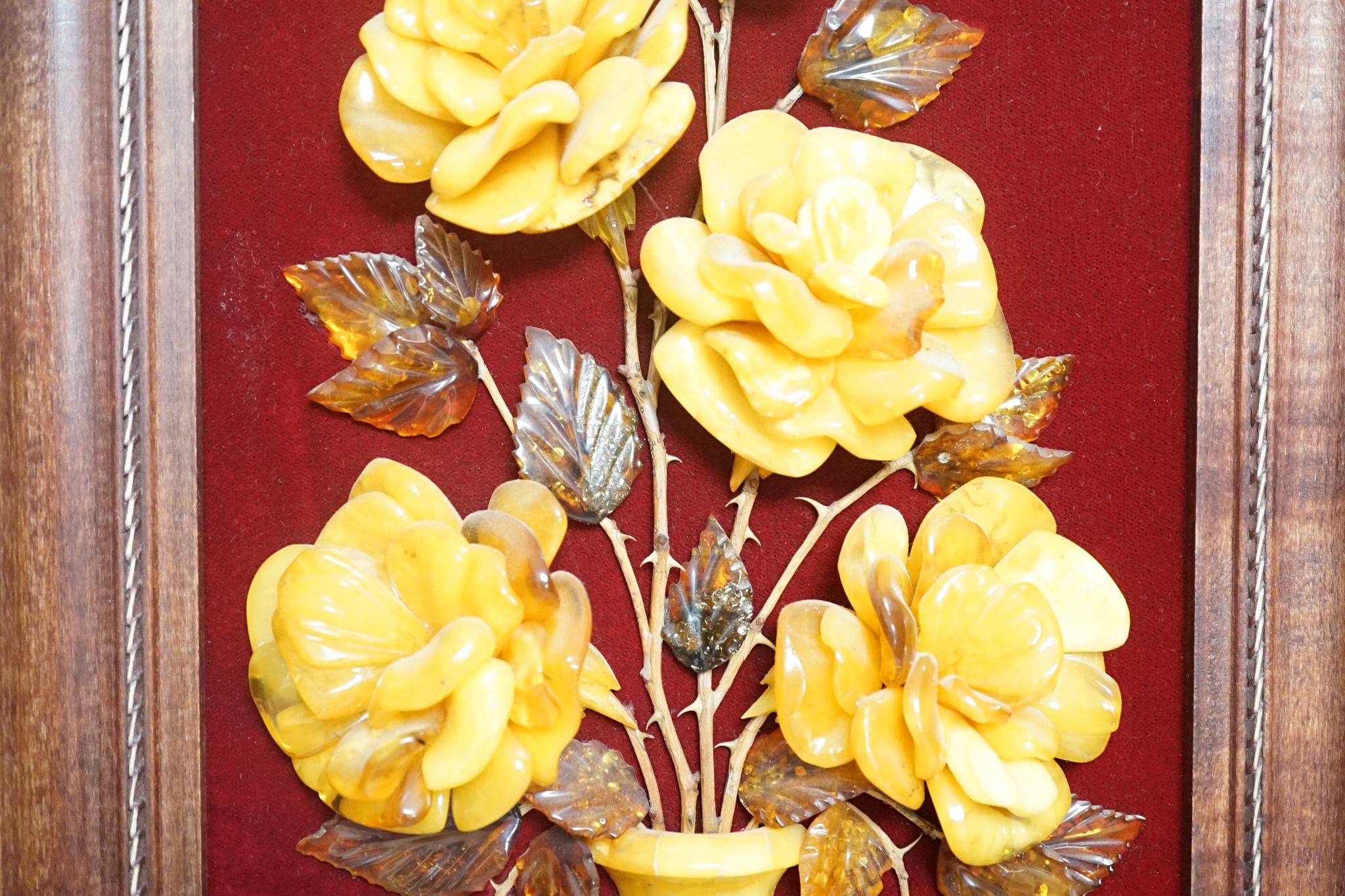 A carved amber panel from the Hermitage Museum shop, St Petersburg, roses in a vase. 49x39cm including frame